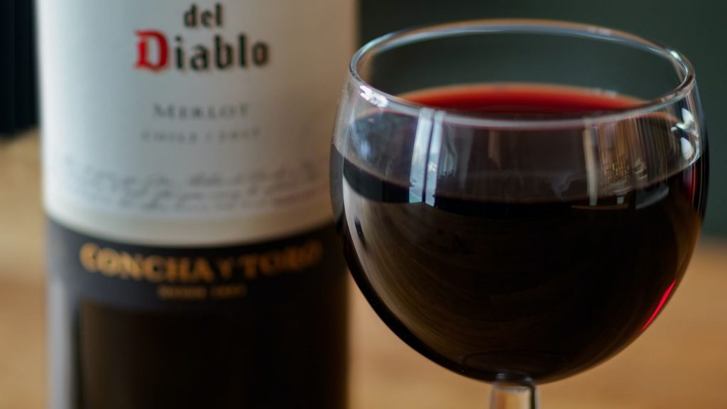 Una botella y una copa llenas de un exquisito vino tinto