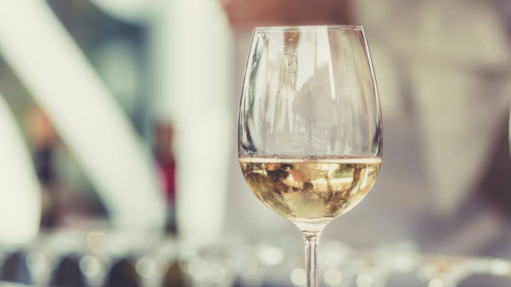 Una copa rebosante de un vino blanco fresco y refrescante